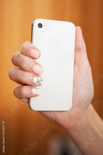 Woman holds in hand wite smartphone