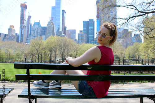 Junge Frau im Central Park mit Blick auf die New Yorker Skyline photo