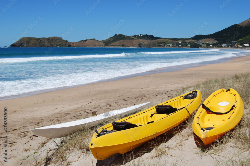 Yellow kayaks on deserted beach