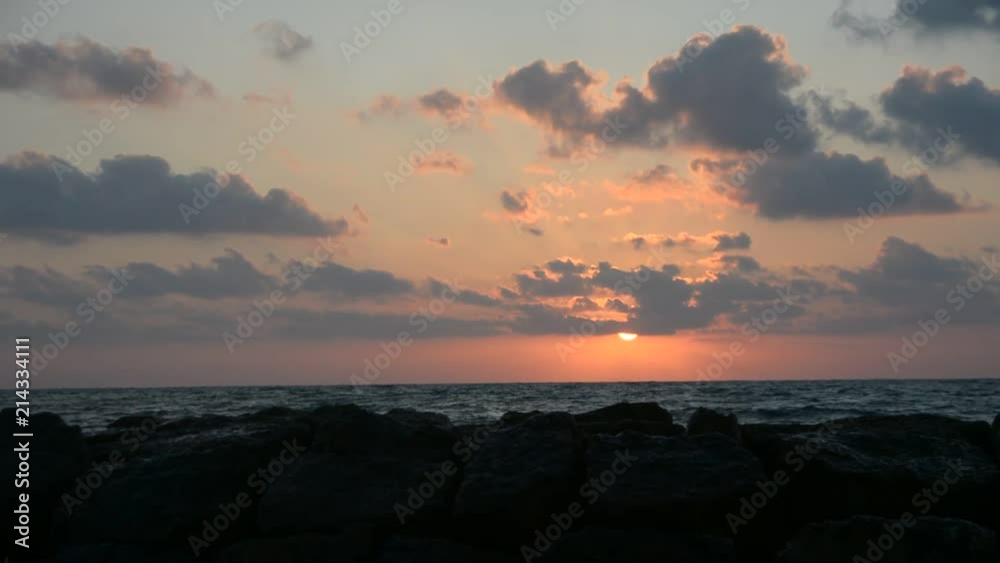 Beautiful sunset at the beach, amazing colors, light beam shining through the cloudscape Beautiful sunset at the beach, amazing colors, light beam shining through the cloudscape