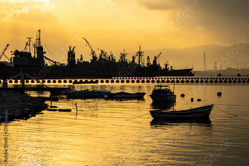 Cuadro en lienzo Navy town and fishing boat at sunset
