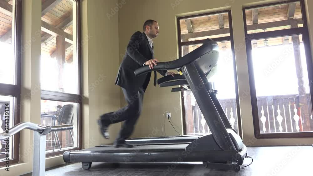 Man with suit running on gym machine, work break, running to succes