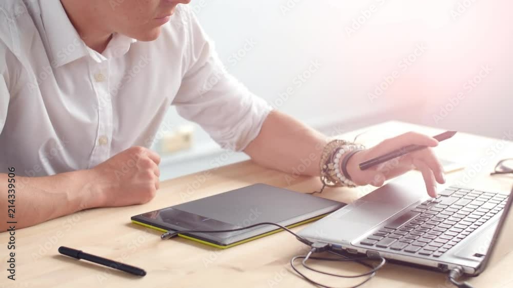 Office work concept. Graphic designer sitting at desk with laptop and tablet