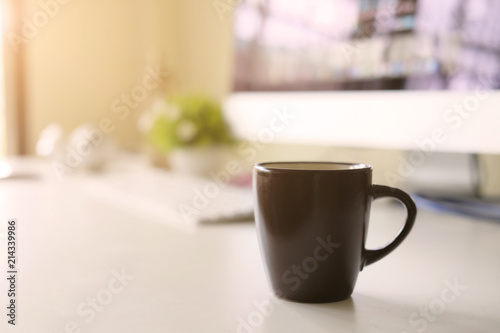 Mug of coffee on office workplace with morning coffee concept.