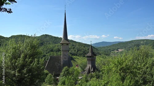 Wooden church with big tower in the middle of green nature, birsana monastery, romania photo