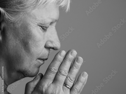 Aged woman prays. Selective focus.
