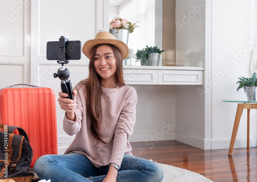 Asian young female blogger recording vlog video with mobile phone live streaming when travel.online influencer on social media viral concept. photo