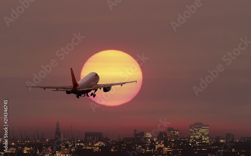 Flugzeug startet über der Stadt Hamburg in die Abendsonne