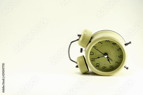 Beige alarm clock, stylized antique with black arrows.