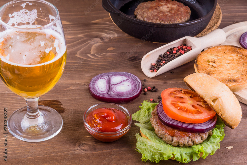 Half empty glass of beer with delicious homemade hamburger Half empty glass of beer with delicious homemade hamburger