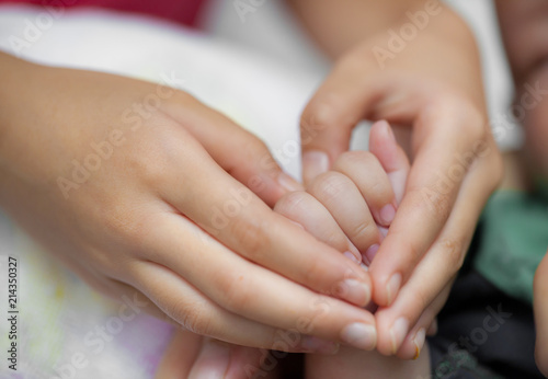 Hand holding a baby hand extreme close-up © alexzeer