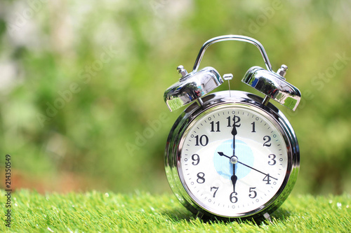 Alarm clock on natural green background,Time concept