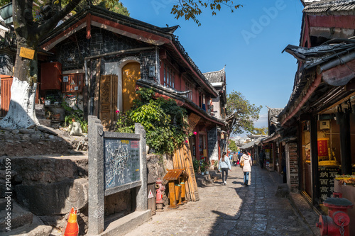 Scenic street in the Old Town of Lijiang, Yunnan province, China. Wooden facades of traditional Chinese houses. The Old Town of Lijiang is a popular tourist destination of Asia.