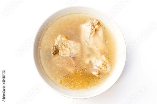 Bowl of pork bone soup with herbs isolated on white background photo