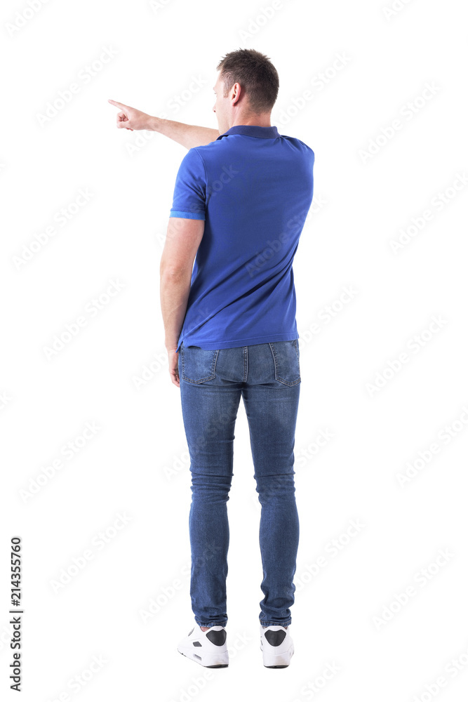 Back view of young man in casual clothes pointing left with right arm finger. Full body isolated on white background. Back view of young man in casual clothes pointing left with right arm finger. Full body isolated on white background.