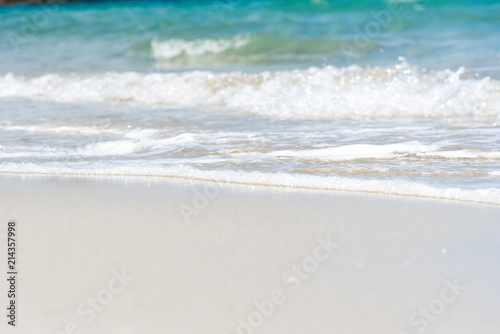 Soft Wave Of Blue Ocean On Sandy Beach in summer. Background. Selective focus.