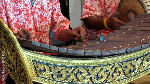 Detail of hands with hammers playing traditional Thai xylophone photo