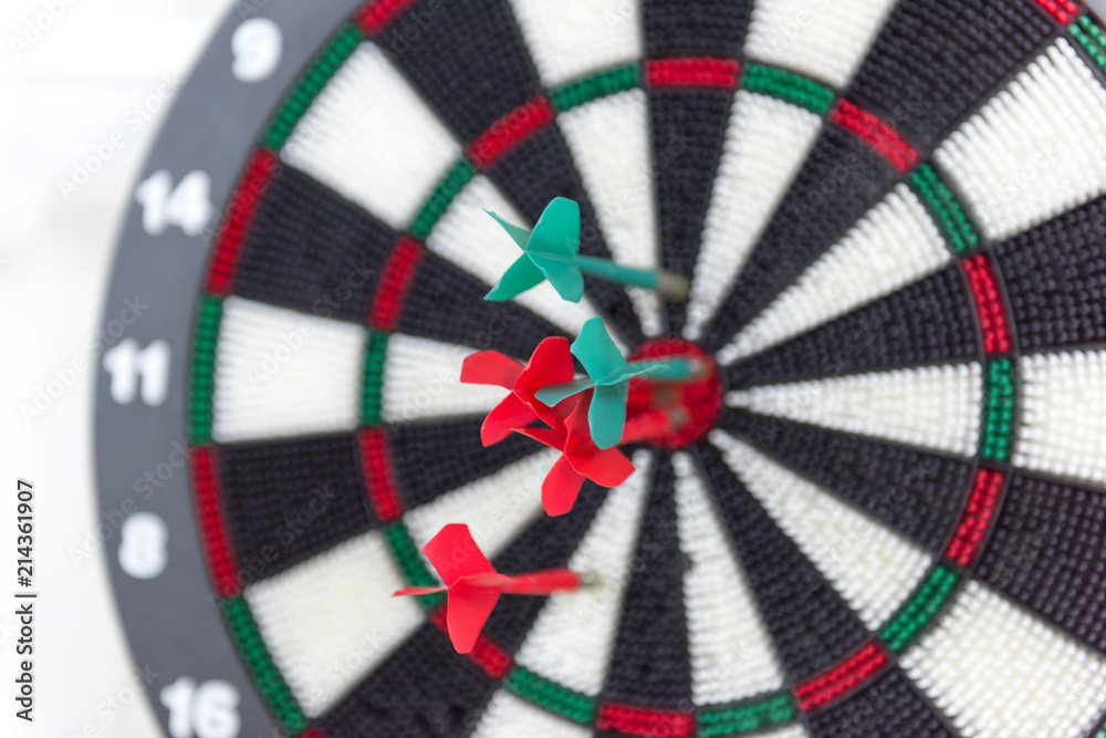 Darts hitting bullseye on dartboard Darts hitting bullseye on dartboard