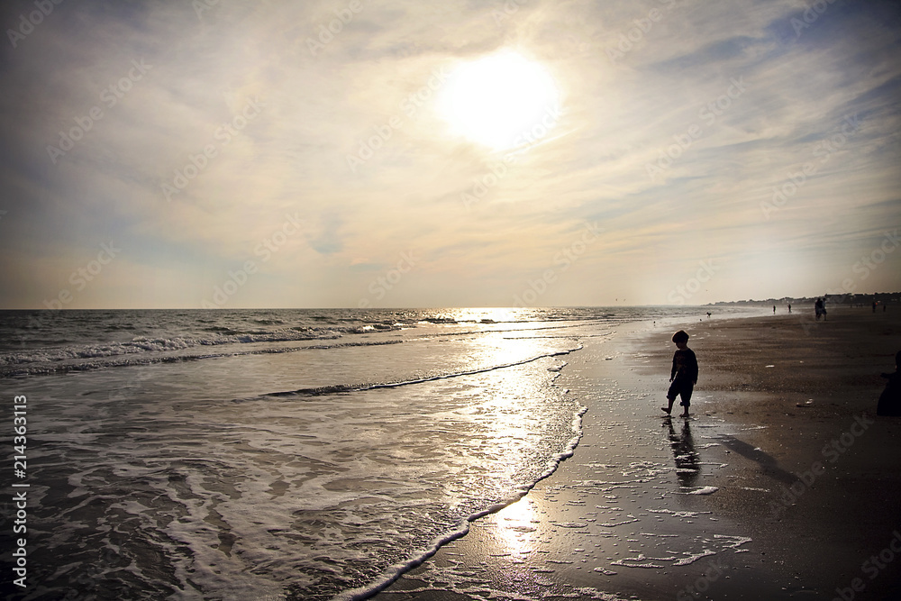 Fototapeta premium Silhouette of Child at Beach at Sunset