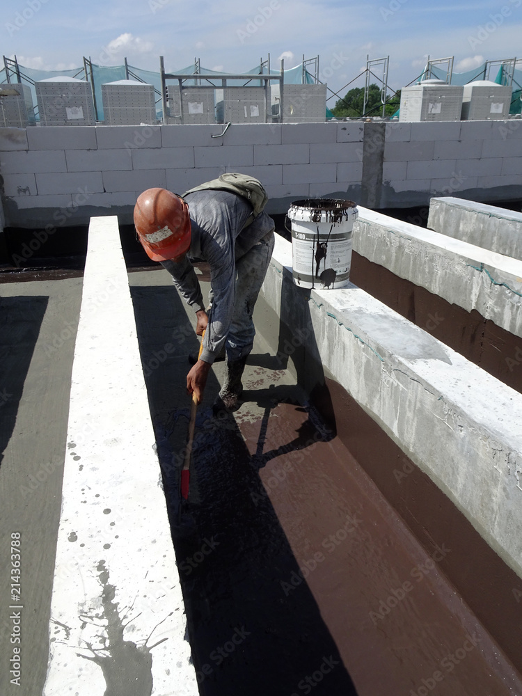 Waterproofing layer applied by construction workers on top of concrete ...