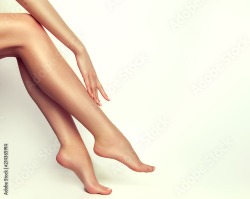 Beautiful well-groomed female legs . Foot care . Depilation of hair on the feet .   © Sofia Zhuravetc
