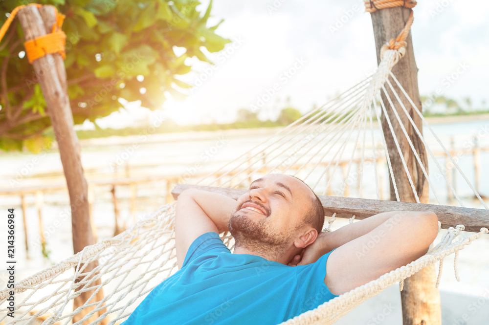 Time for laziness. The man lies in a hammock and enjoys the rest