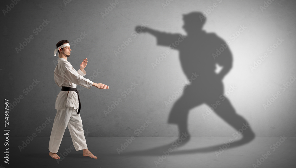 Young karate man confronting with his own shadow
Young karate man confronting with his own shadow