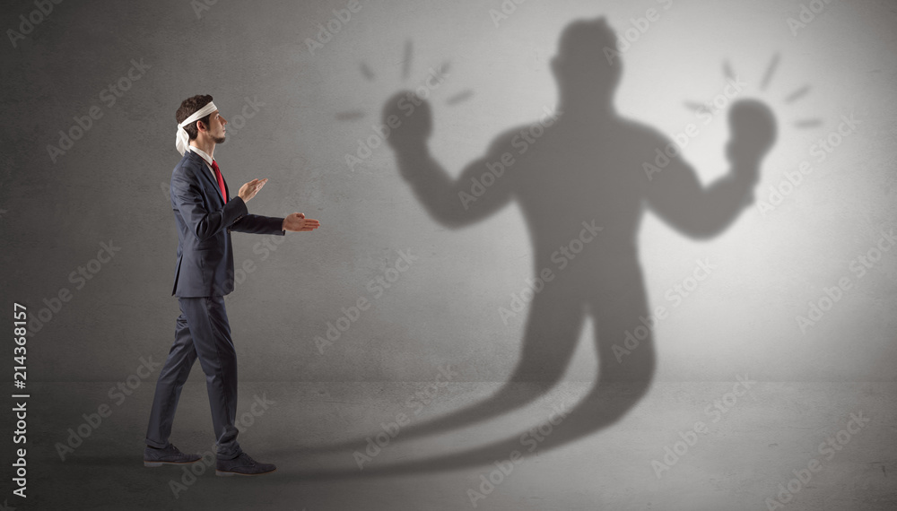Businessman trying to fight with his unarmed shadow
Businessman trying to fight with his unarmed shadow