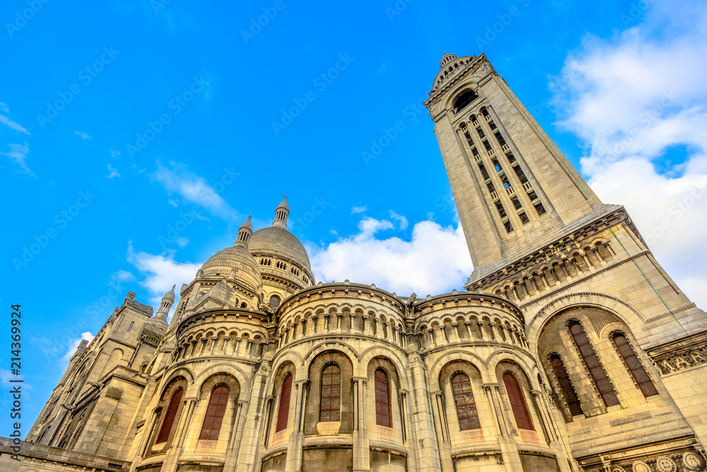 Back side of Sacre Coeur Basilica de Montmartre in a beautiful sunny day with blue sky. Sacred Heart Church of Paris in France, Europe. Popular religious attraction in Paris.