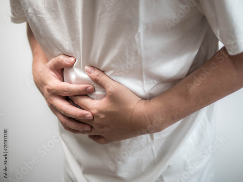 Mature man overwhelmed with a pain in the stomach on white background, Poisonous food, stomach problems