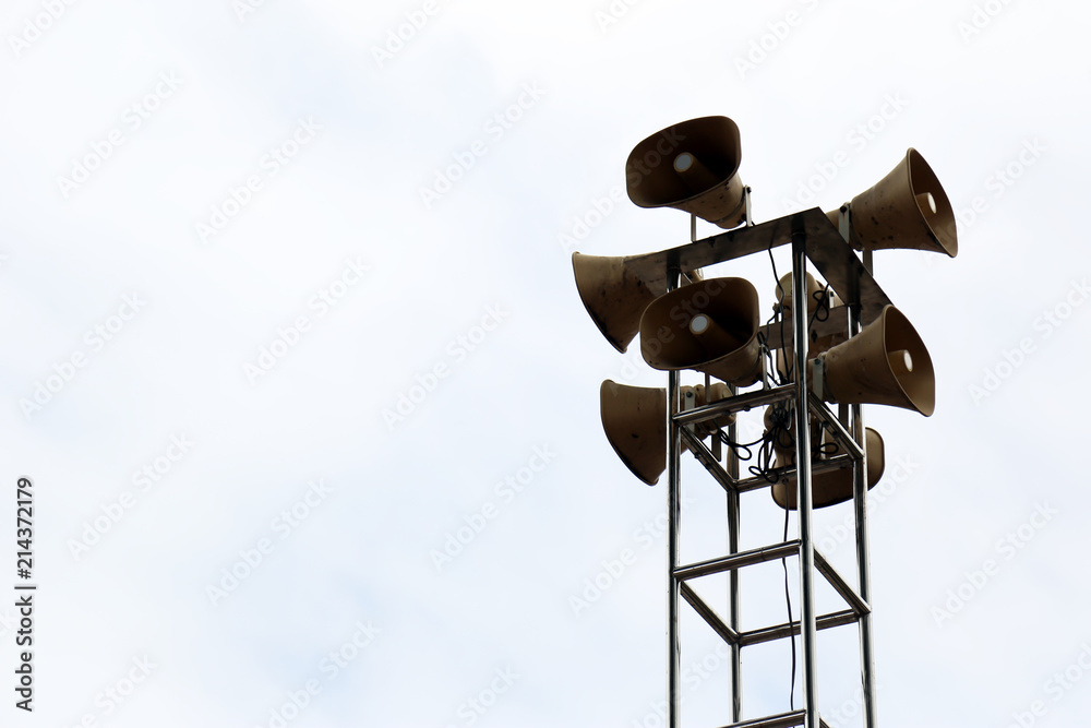 Loudspeaker tower for public relations on metal pole isolated in the bright sky.