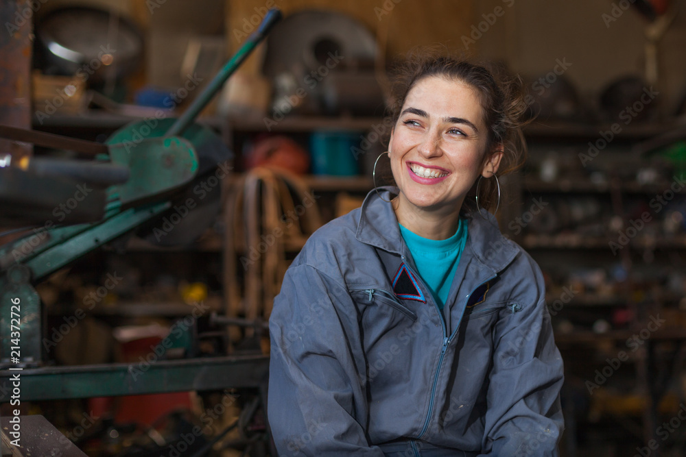 young woman mechanic in a workshop - obrazy, fototapety, plakaty 