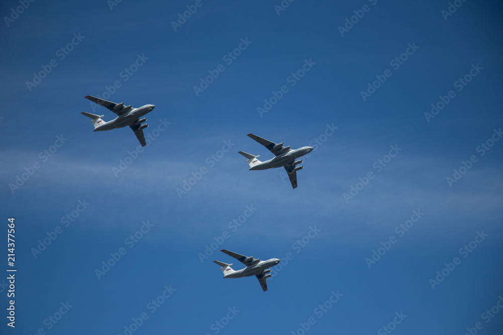 Military airplanes lined up in a row during the Russian military parade on bright blue sky with clouds in spring Military airplanes lined up in a row during the Russian military parade on bright blue sky with clouds in spring