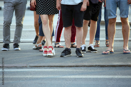 feet of people waiting for green light on the road