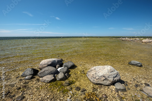 rocky sea beach with waves and sunny day