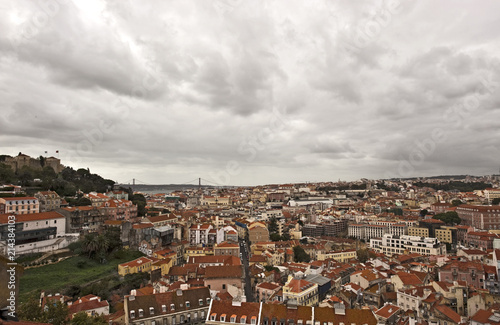 Aussicht vom Miradouro da Graca auf die Burg Castelo de Sao Jorge und die Stadt bei bewölktem HImmel, hinten die Brücke Ponte 25 de Abril, Lissabon; Lisboa; Portugal