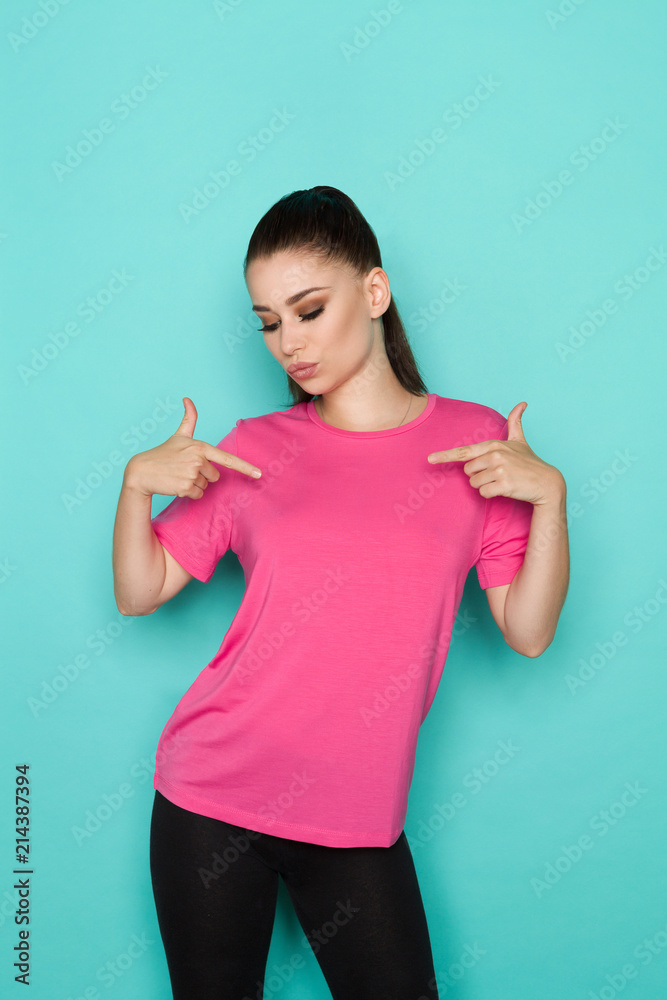 Confident Young Woman In Pink Shirt Is Pointing At Herself. Confident Young Woman In Pink Shirt Is Pointing At Herself.
