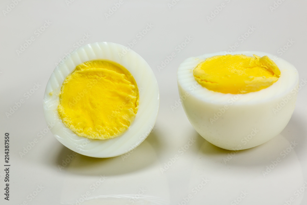 Hardboiled eggs with one cut in half on a plate at the kitchen table Hardboiled eggs with one cut in half on a plate at the kitchen table