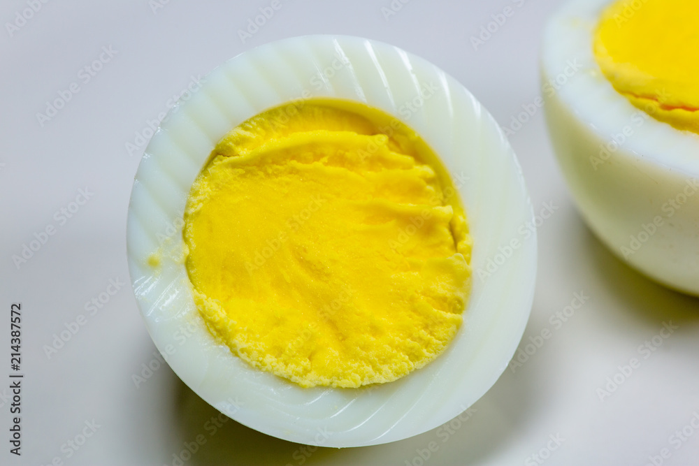Hardboiled eggs with one cut in half on a plate at the kitchen table Hardboiled eggs with one cut in half on a plate at the kitchen table