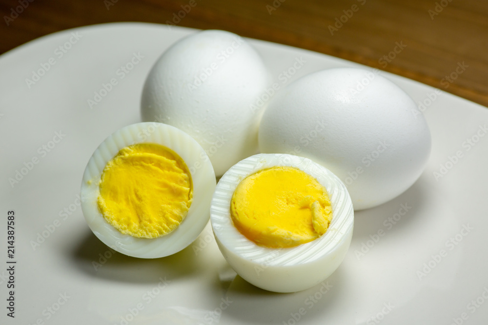 Hardboiled eggs with one cut in half on a plate at the kitchen table Hardboiled eggs with one cut in half on a plate at the kitchen table