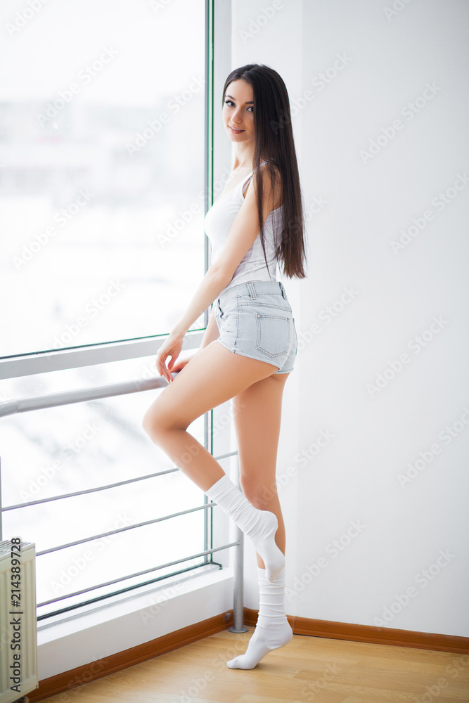 Fototapeta premium Beautiful woman standing near windows. Beautiful morning