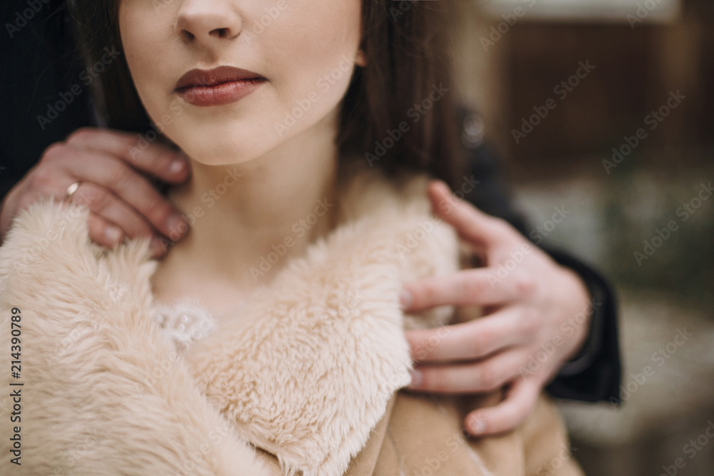 stylish groom sensually hugging gorgeous bride neck at wooden house. wedding couple embracing in snowy park. barn wedding. romantic sensual moment of newlyweds stylish groom sensually hugging gorgeous bride neck at wooden house. wedding couple embracing in snowy park. barn wedding. romantic sensual moment of newlyweds