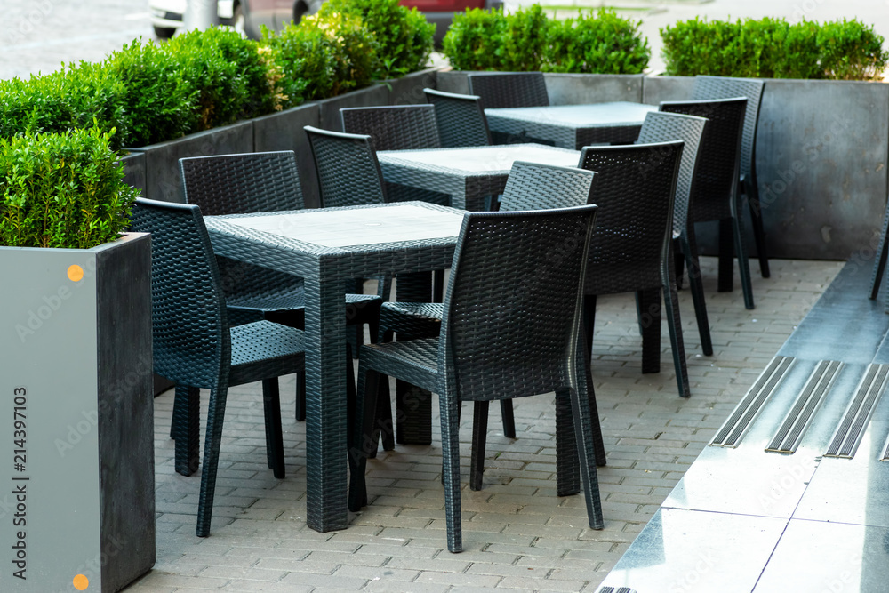 Tables and chairs in a street cafe made of rattan, Street furniture for restaurants and cafes.