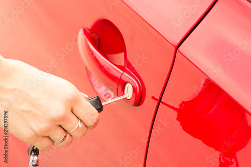 Close-up, the girl opens the door of a red car photo
