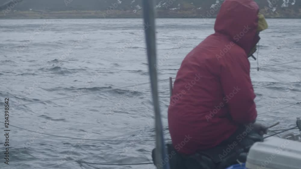 Sea ship mooring to barrel floating in water. Sailor man knots rope on ship