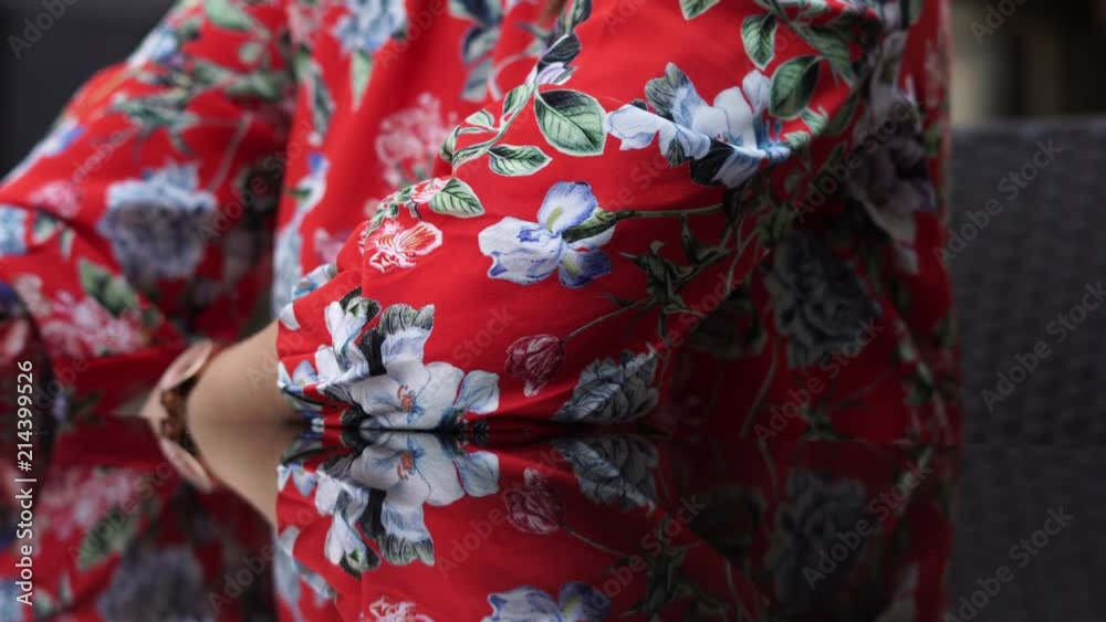 Beautiful girl in red dress, with flower pattern on the terace, outdoor in business centr. Beautiful girl in red dress, with flower pattern on the terace, outdoor in business centr.