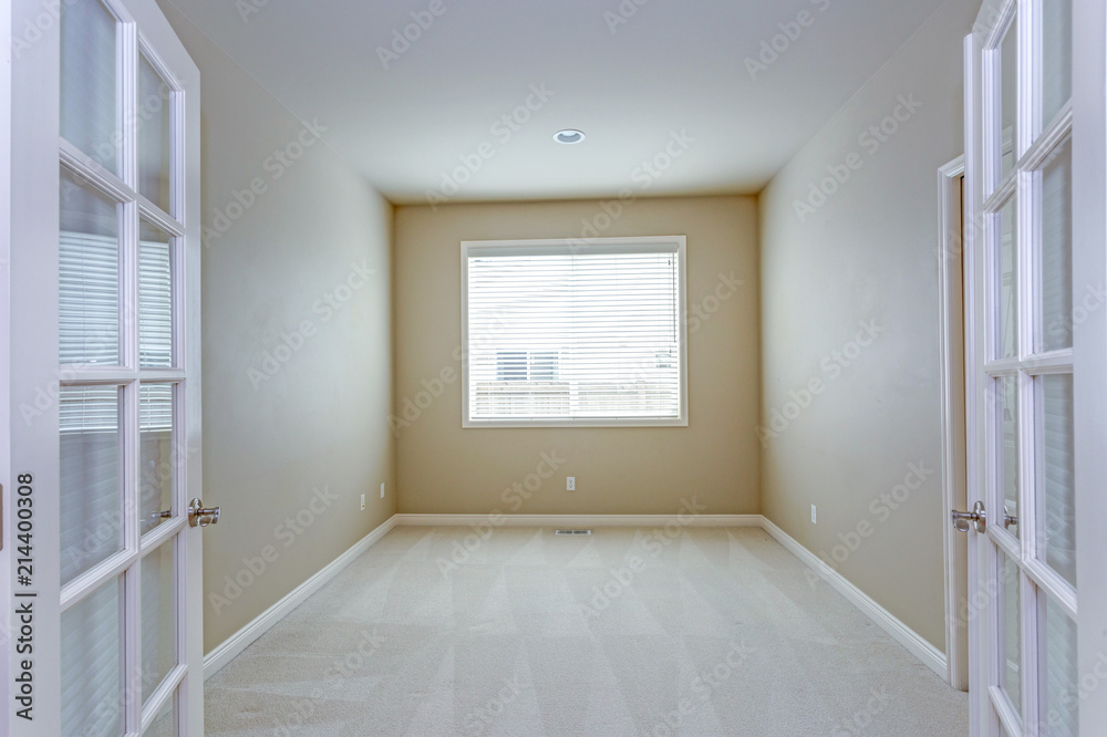 Glass double doors open to an empty room with carpet floor.