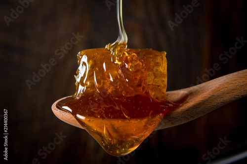 Honey Flows Over Comb in Wooden Spoon