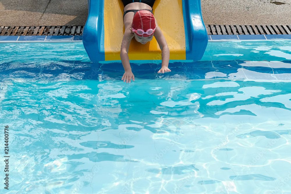 a girl playing swimming pool slider in swimmimg pool