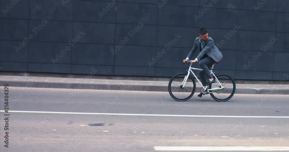 TRACKING Handsome young adult man wearing suit riding his classic bicycle to work in the morning. 4K UHD 60 FPS SLOW MOTION TRACKING Handsome young adult man wearing suit riding his classic bicycle to work in the morning. 4K UHD 60 FPS SLOW MOTION